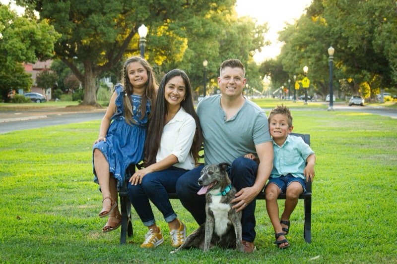 Ariana with her husband, their two children and their dog on the grass at a District 7 neighborhood park